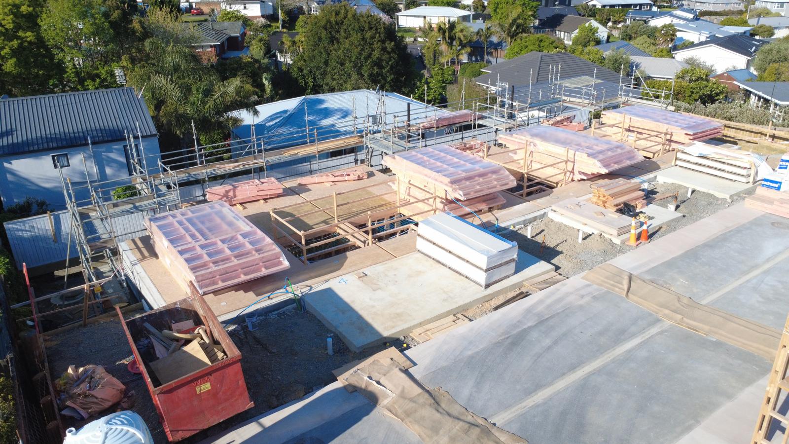 Delivered upper-floor frames stacked on the decks, ready for installation · October 2026